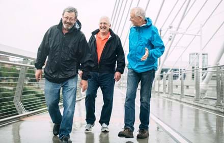 Elderly Men Walking Across Bridge