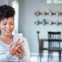 Woman Uses Smart Phone For Virtual Doctor's Appointment From Home