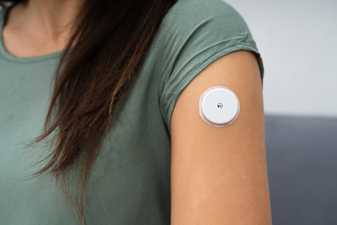 Woman Testing Glucose Level With A Continuous Glucose Monitor