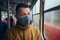 A man wearing a face mask on public transport 