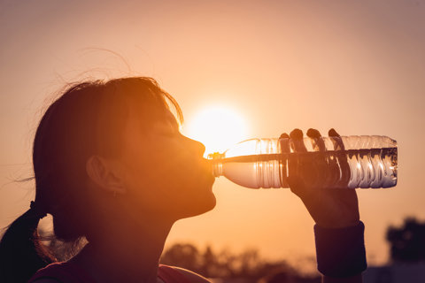 Woman Drinking Water In Hot Weather